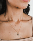 Close-up of a woman wearing a Becoming Jewelry On Fire Necklace with a flame charm pendant.