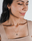 Woman gazing to the side wearing a gold filled On Fire Necklace by Becoming Jewelry and a sleeveless top.