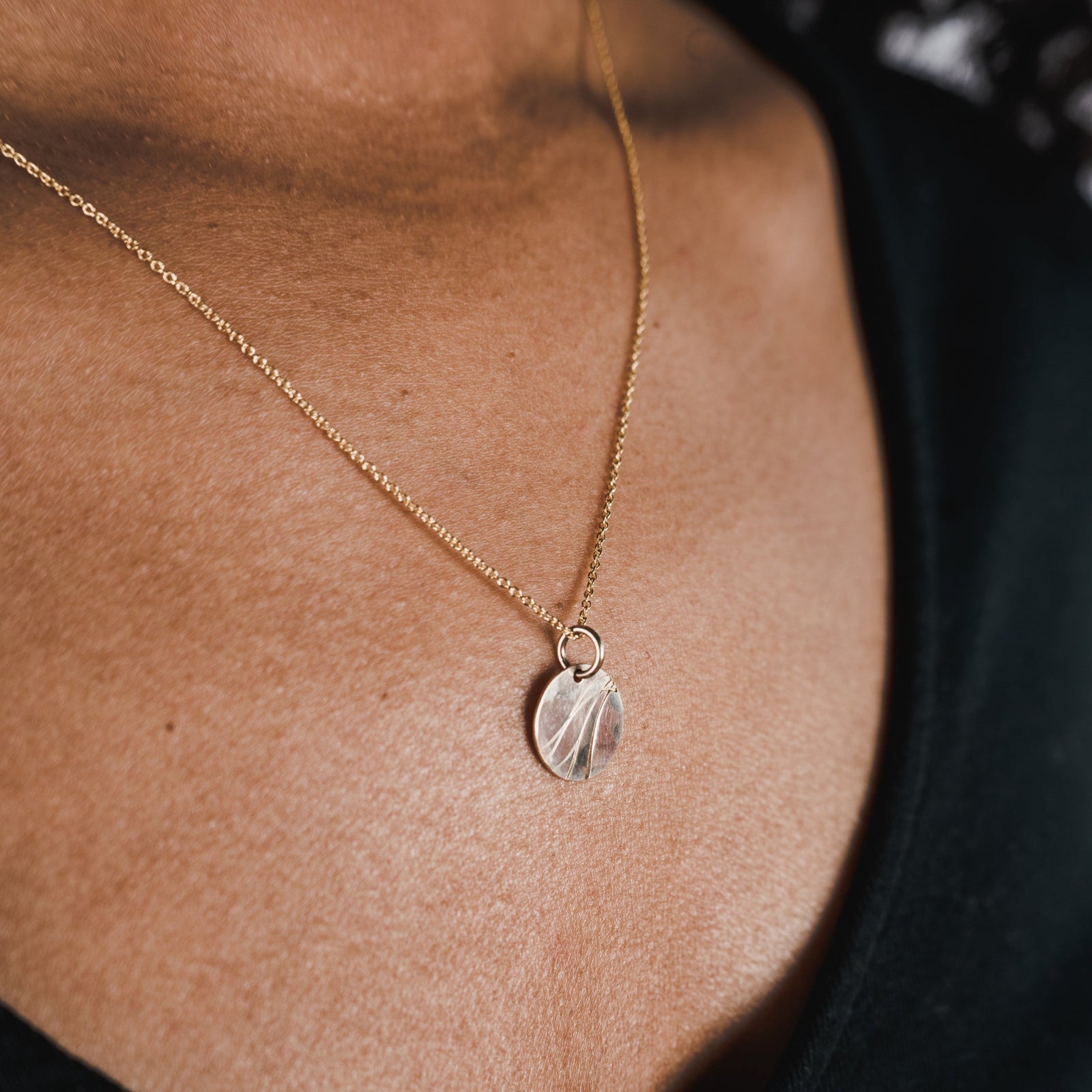 River Necklace with a leaf pendant charm, worn by a person, designed by Becoming Jewelry.