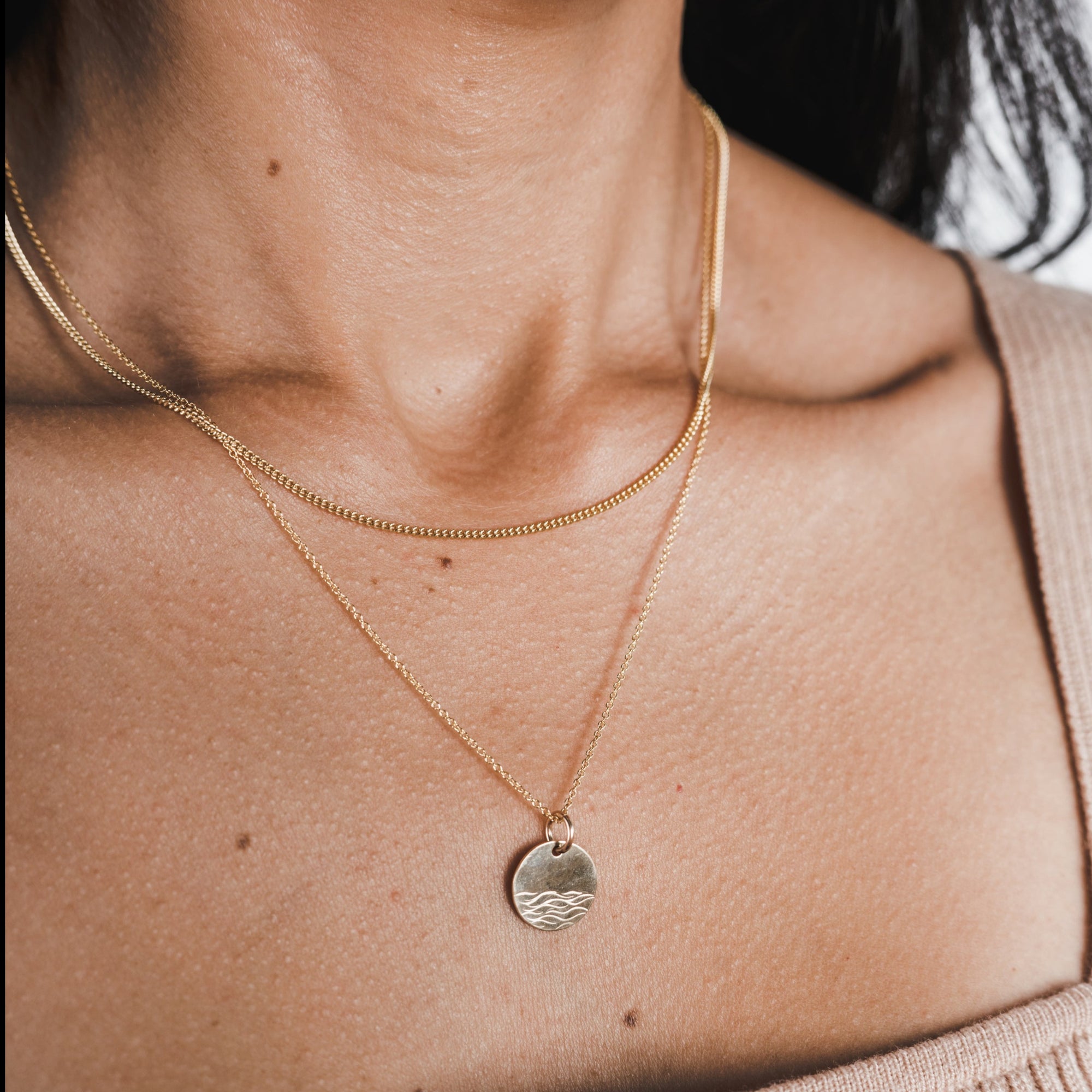 Woman wearing a delicate, Becoming Jewelry gold-filled Sea Necklace with a round pendant.