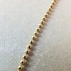 Becoming Jewelry gold-filled Bead Chain Necklace on a textured background.