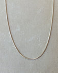 Becoming Jewelry Sterling silver box chain necklace on a grey background.