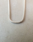 Close-up of the lightweight Becoming Jewelry Box Chain Necklace with small rectangular links, displayed on a light beige surface, exuding a classic look.