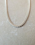 The Friendship Circles Necklace Layered Set from Becoming Jewelry rests elegantly on a beige textured surface, exuding understated grace.