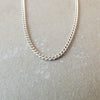 A Becoming Jewelry sterling silver curb chain necklace displayed on a gray background.