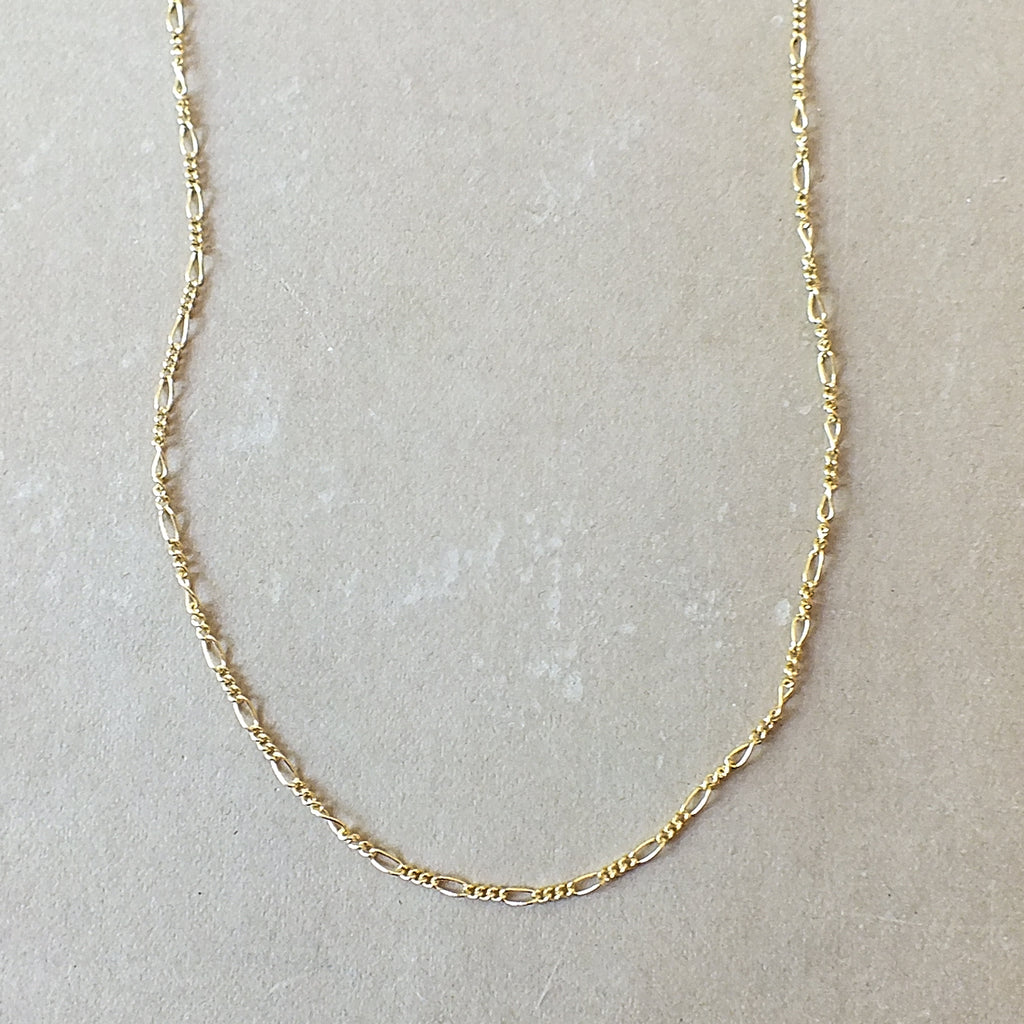 Becoming Jewelry's Gold Filled Figaro Chain necklace on a neutral background.
