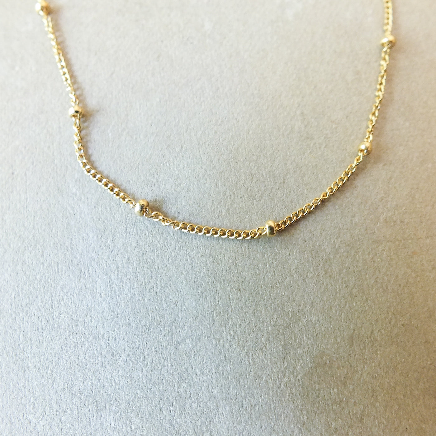 Satellite Chain Necklace by Becoming Jewelry on a white surface.