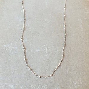 Becoming Jewelry's sterling silver Satellite Chain Necklace is featured on a gray background.