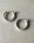 A pair of sterling silver Becoming Jewelry Everyday Hoop Earrings, medium on a gray background.