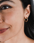 Close-up of a smiling woman with Becoming Jewelry Gold Filled Everyday Hoop Earrings, large.