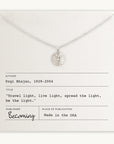Becoming Jewelry's "Be The Light Necklace" displayed on a card with an inspirational quote by Yogi Bhajan and branding information.