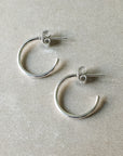 Open hoop earrings, medium from Becoming Jewelry on a light grey surface.