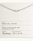 The Stick Together Necklace from Becoming Jewelry highlights a silver charm presented on a card with Walt Whitman's quote, "Shall we stick by each other As long as we live?" It celebrates meaningful connections and includes information about the author, title, publisher, and place of publication.