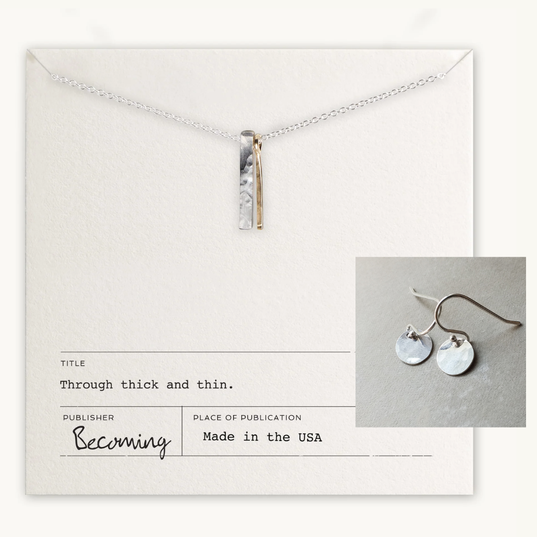 The Through Thick & Thin Necklace + Earrings Set by Becoming Jewelry features silver and gold vertical bars on a card with an image of matching mixed metal earrings. Made in the USA.