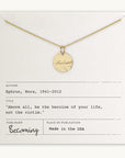 The Badass Necklace from Becoming Jewelry features a gold circular pendant with the word "badass" engraved in an antique handwriting font. It is beautifully displayed on a card that includes a powerful quote by Nora Ephron: "Above all, be the heroine of your life, not the victim." This piece offers you a daily dose of empowerment.