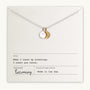 The "Count My Blessings Necklace" by Becoming Jewelry features a silver necklace with a round and crescent moon pendant, elegantly displayed on paper inscribed with the thoughtful phrase, "When I count my blessings, I count you twice," alongside other publication details. This charming gift pairs beautifully with silver drop discs.