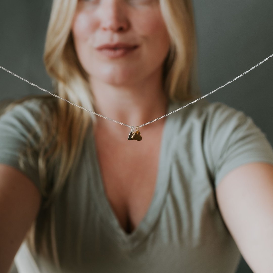 Model holding Tiny Hearts necklace