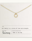 A gold necklace with a circular pendant is displayed on a card that reads, "Our family is a circle of love and strength." Published by Becoming Jewelry and made in the USA, this Family Circle Necklace makes the perfect go-to gift.