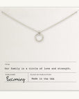 The Family Circle Necklace by Becoming Jewelry features a silver circle pendant displayed on a card that reads: "Our family is a circle of love and strength." Made in the USA, this piece from Becoming Jewels is the perfect go-to gift, symbolizing strength and love for any family member.