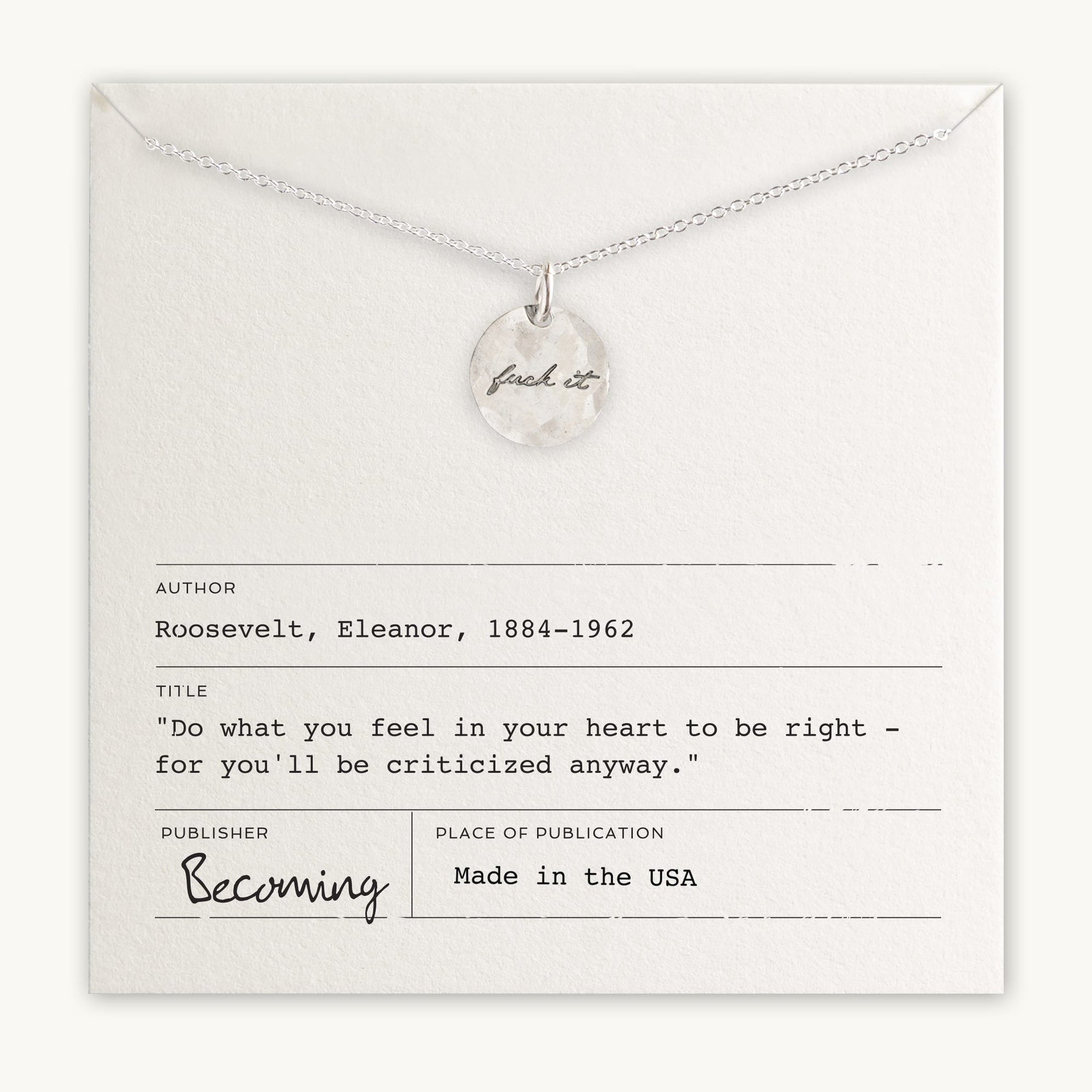 A Fuck It Necklace featuring a sterling silver circular pendant inscribed with &quot;just do it&quot; displayed above an inspirational quote by Eleanor Roosevelt on a card, by Becoming Jewelry.