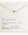 Becoming Jewelry's Love Knot Necklace with a knot pendant displayed on a card with an Audrey Hepburn quote.