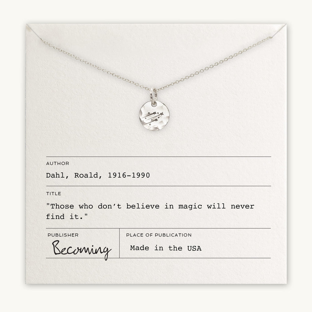 A Becoming Jewelry Believe in Magic Necklace with a shooting stars charm displayed on a card featuring a quote by Roald Dahl.