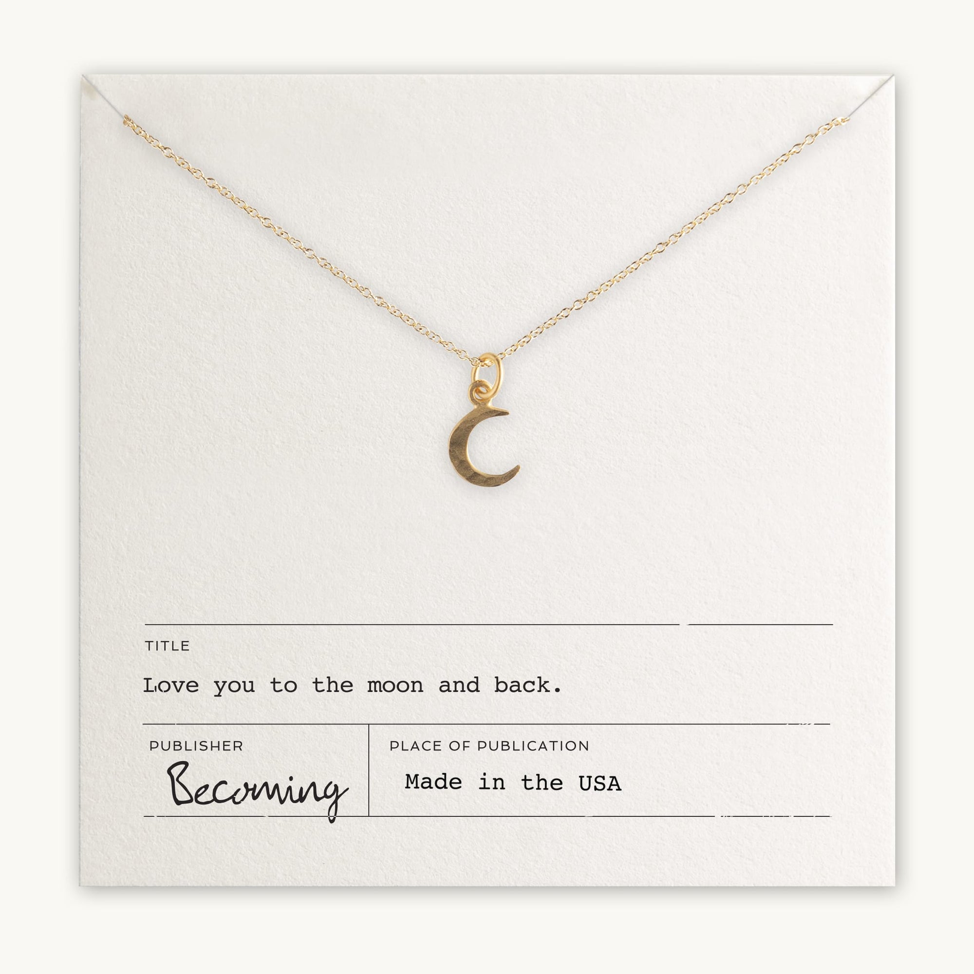 The Love You To The Moon Necklace by Becoming Jewelry is a delicate gold piece featuring a crescent moon pendant and displayed on a card with the words "Love you to the moon and back." Made in the USA, this meaningful necklace serves as a daily reminder of love and affection.