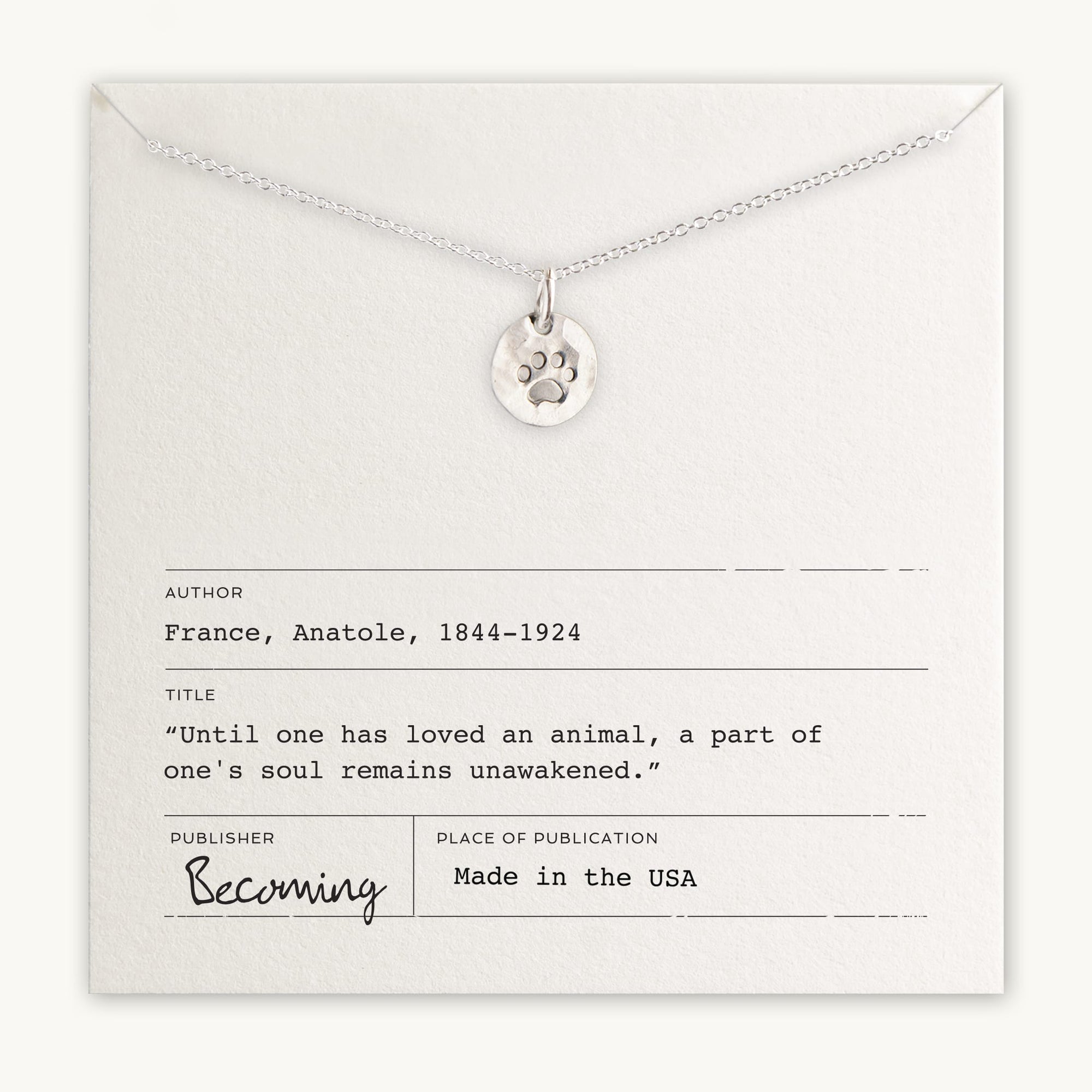 Becoming Jewelry&#39;s Paw Print Necklace with paw print charm pendant presented on a card with an Anatole France quote.