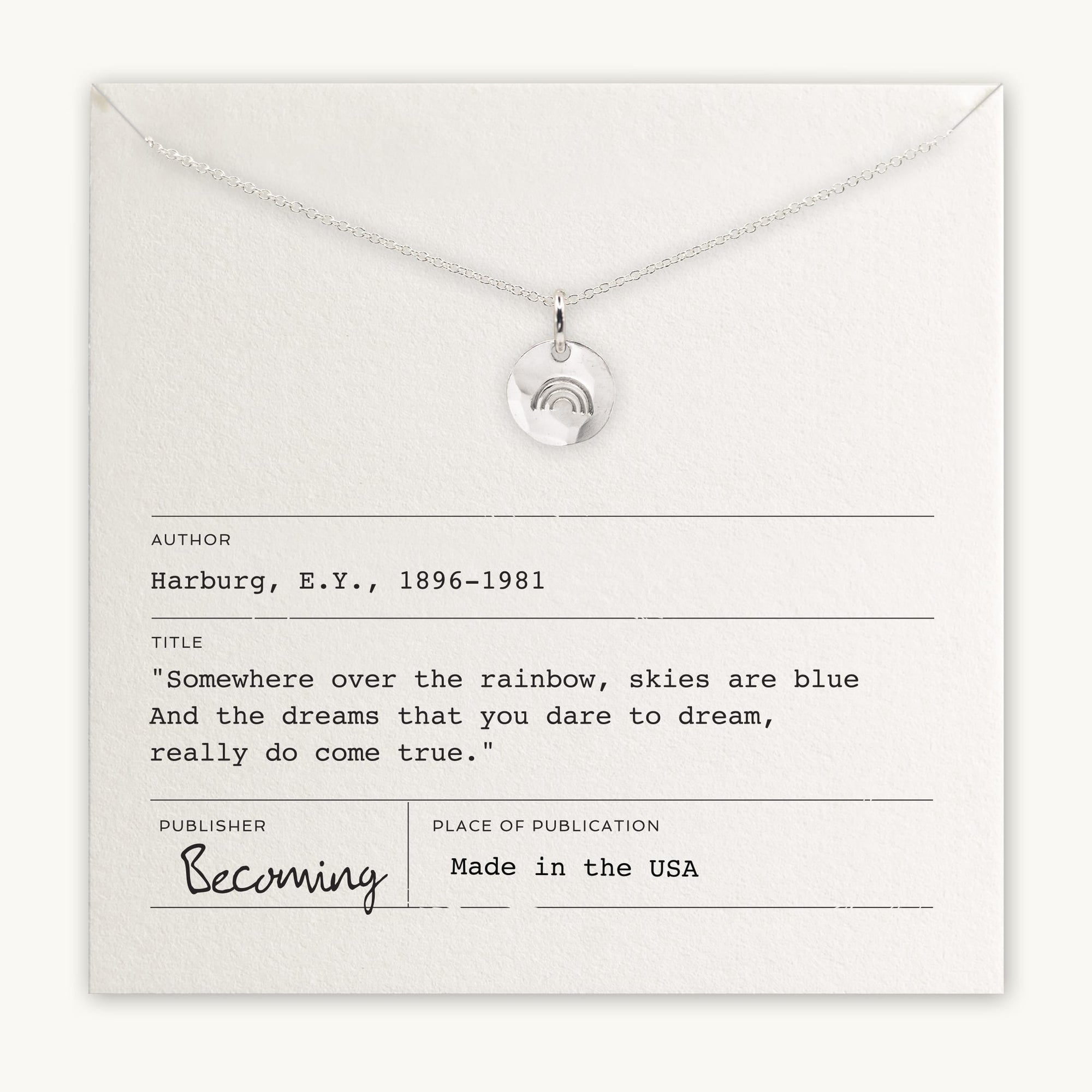 Becoming Jewelry&#39;s Over the Rainbow Necklace, with a Rainbow Charm pendant displayed on a card featuring a quote about dreams and a rainbow, labeled as made in the USA.