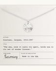 The Sea Necklace, a silver piece by Becoming Jewelry, showcases a circular pendant adorned with an ocean wave design. Presented on a card featuring a quote from Jacques Cousteau and proudly stating 'Made in the USA,' this elegant necklace is an ideal sea-inspired gift.