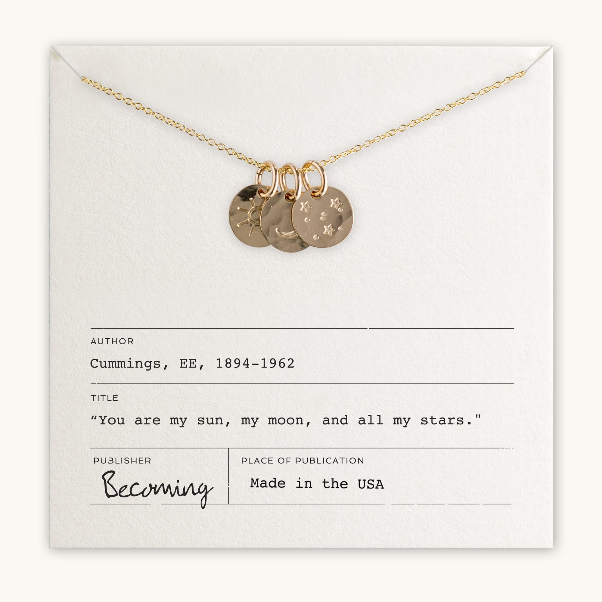 The Sun Moon and Stars Necklace by Becoming Jewelry, featuring four star-stamped pendants and a moon charm, is displayed on an envelope with printed text attributing a quote to E. E. Cummings (1894-1962) and noting that the item is made in the USA.