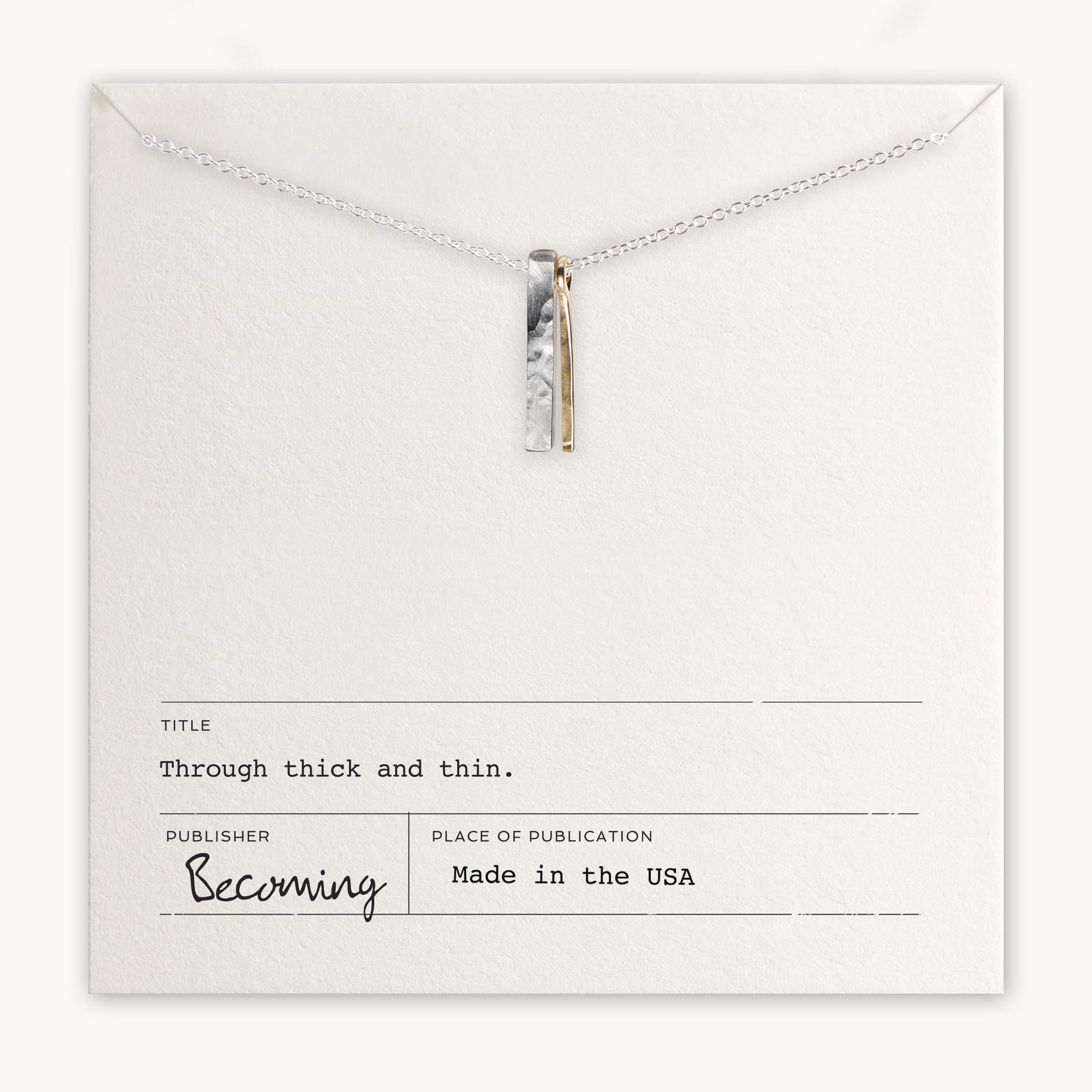 The Through Thick & Thin Necklace by Becoming Jewelry is a best-selling piece featuring silver and gold bar pendants displayed on a card reading "Through Thick & Thin." Made in the USA, this necklace makes a perfect gift.