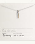 The Through Thick & Thin Necklace by Becoming Jewelry is a best-selling piece featuring silver and gold bar pendants displayed on a card reading "Through Thick & Thin." Made in the USA, this necklace makes a perfect gift.