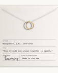 The True Friends Necklace, featuring two mixed metal interlocking circles, is presented on a card with the text, "True friends are always together in spirit," by L.M. Montgomery. This beautiful piece is crafted by Becoming Jewelry and made in the USA.