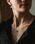 Woman wearing a Friends Beads Necklace from Becoming Jewelry and delicate earrings.