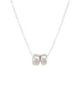 The Friends Beads Necklace by Becoming Jewelry is a delicate silver chain featuring two small silver beads side by side in the center, making it a meaningful gift perfect for dearest friends.