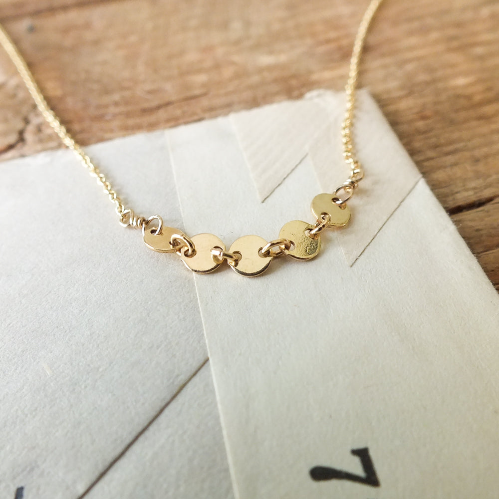 Mothers &amp; Daughters Necklace with circular interlinked charms on a piece of paper by Becoming Jewelry.