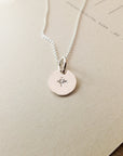 Round pendant Light Within Necklace with a starlight charm engraving on a light background by Becoming Jewelry.