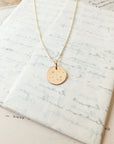 Watch the Stars Necklace" by Becoming Jewelry with embossed design displayed on a piece of textured paper.