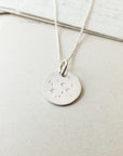 A Becoming Jewelry Watch the Stars Necklace with stars charm and moon motifs on a chain, displayed on a light background.