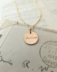 Badass Necklace with "isabela" inscription on a backdrop of vintage letters by Becoming Jewelry.