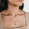 Close-up of a woman wearing a Becoming Jewelry On Fire Necklace with a flame charm pendant.