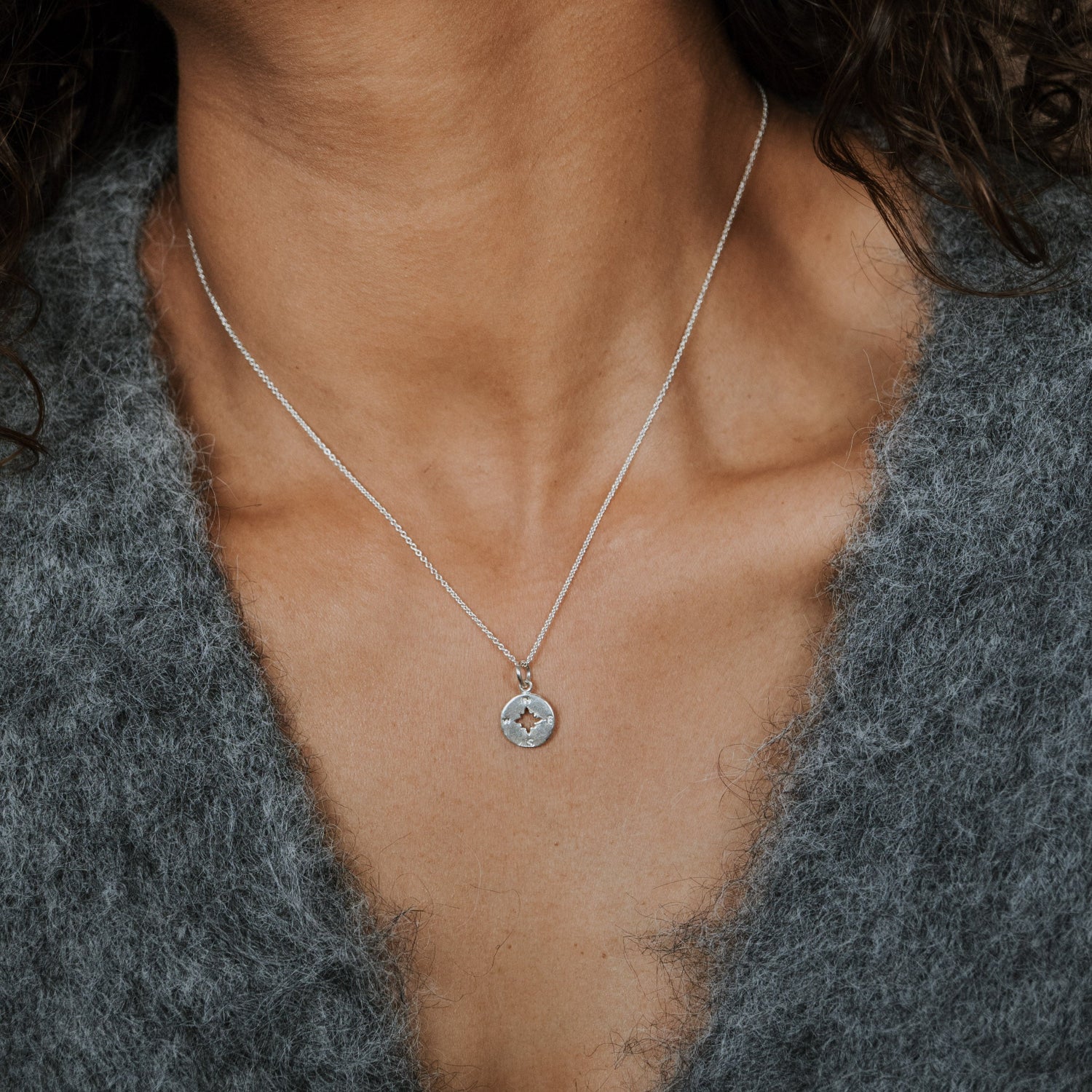 Woman wearing compass charm necklace