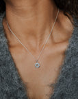 Woman wearing compass charm necklace