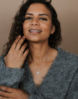 Woman wearing a gray sweater against a beige background