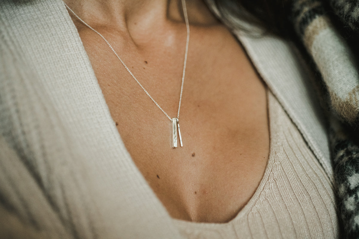 Necklace with a pendant worn by a person in a neutral setting