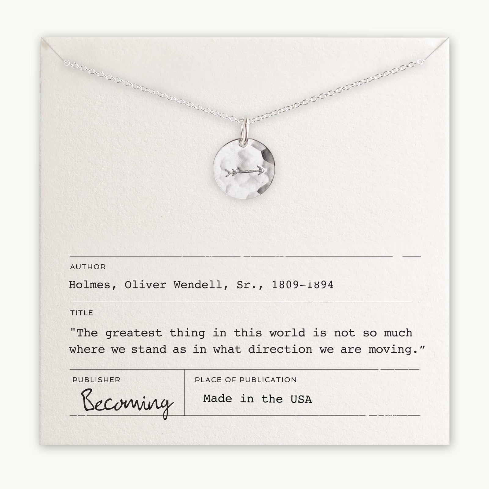 A Becoming Jewelry necklace with an Arrow Necklace pendant, an arrow charm, and an inspirational quote by Oliver Wendell Holmes Sr. displayed on the packaging.