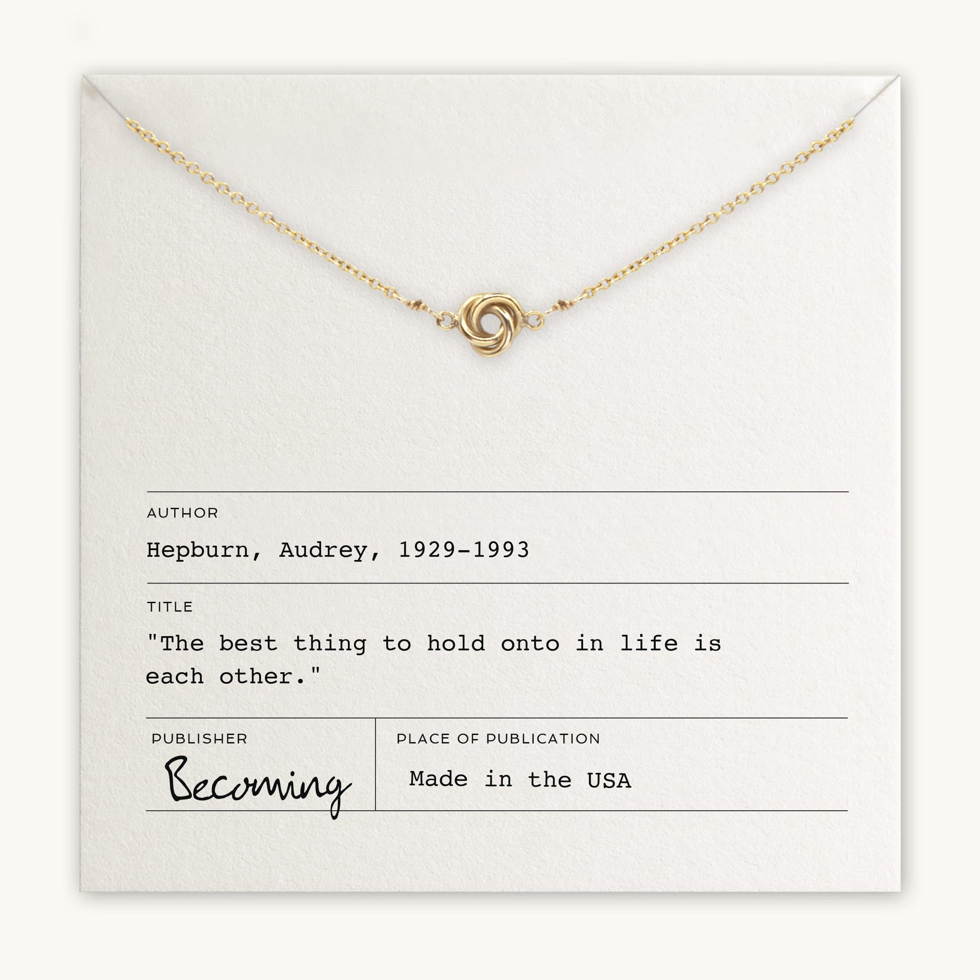 Becoming Jewelry&#39;s Love Knot Necklace with a knot pendant displayed on a card with an Audrey Hepburn quote.