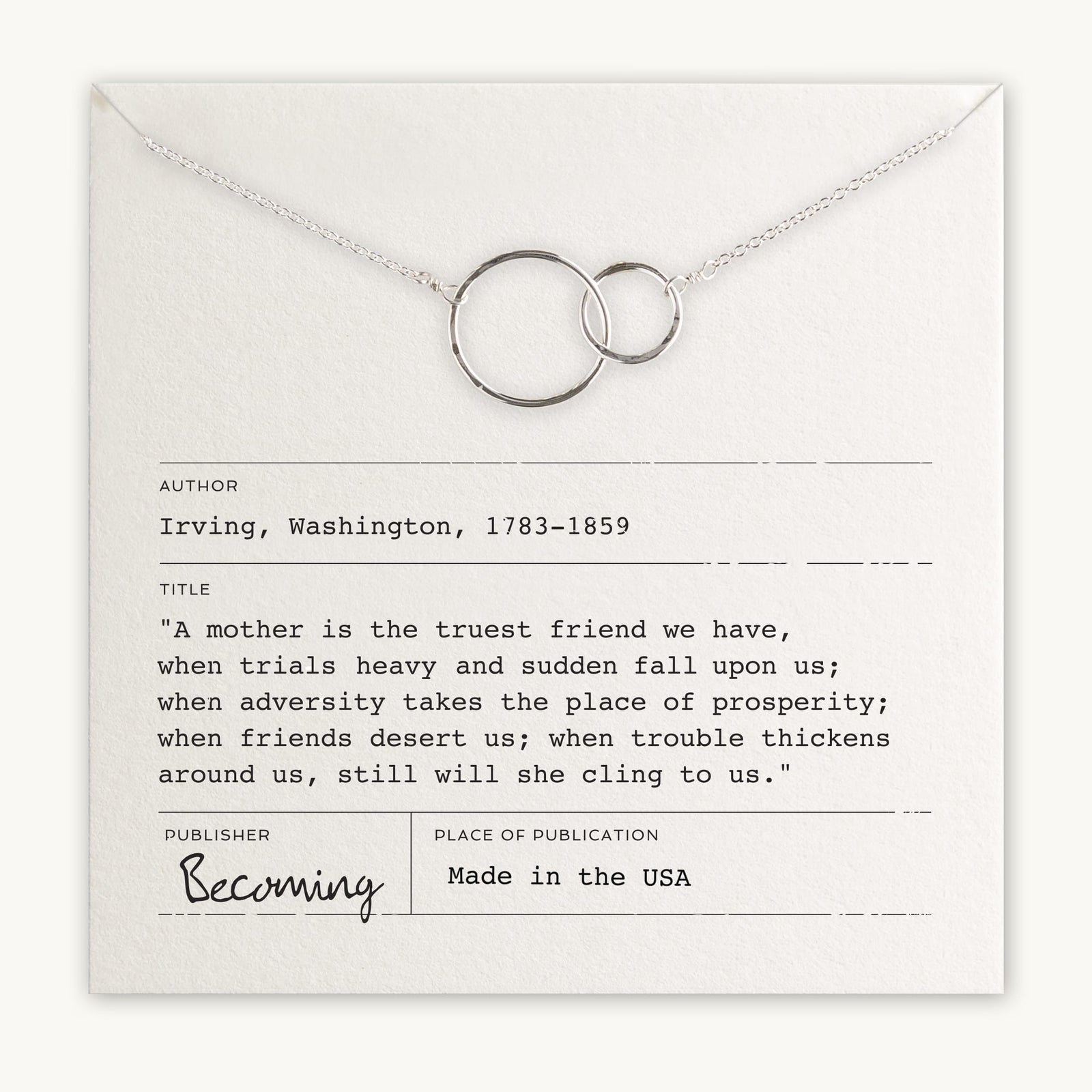 Becoming Jewelry's silver Mother Necklace with interlocking rings is laid on a card featuring a quote by Washington Irving.