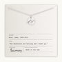 The "Mountains Are Calling Necklace" by Becoming Jewelry showcases a silver necklace adorned with a small mountain charm pendant, gracefully presented on a card. The card features an inspiring quote by John Muir: "The mountains are calling and I must go." It's the ideal gift for nature and adventure enthusiasts.